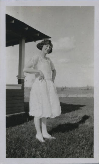 Untitled [Woman stands on field, hands on hips]