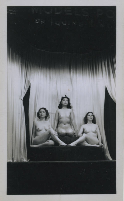 Untitled [Three women sit onstage, curtain in the background]