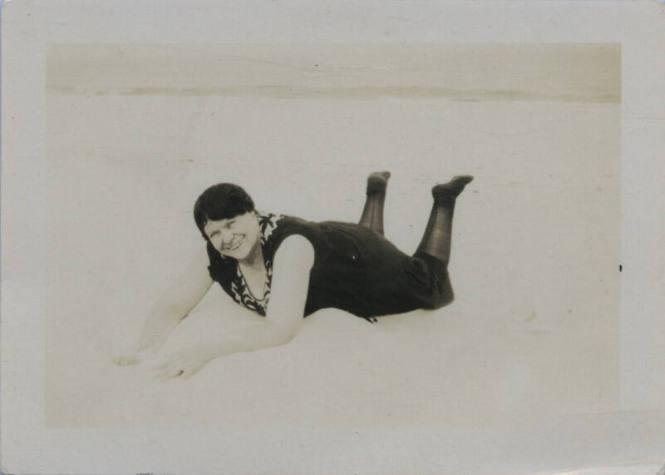 Untitled [Woman lies on stomach in what seems to be a beach]