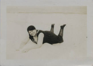 Untitled [Woman lies on stomach in what seems to be a beach]