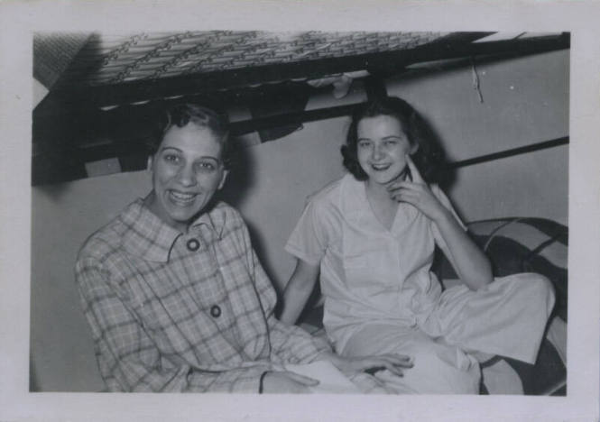 Untitled [Two women sit on bottom bunk bed]