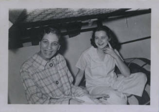 Untitled [Two women sit on bottom bunk bed]
