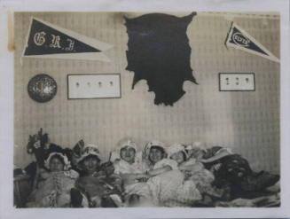 Untitled [Six women lying on bed, banners above read G.R.J. and Culver]