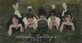 Untitled [Five women lie on lawn, woman in middle holds ball that reads BB1921]