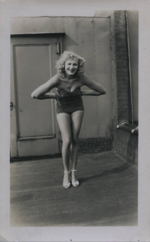 Untitled [Woman leans forward, hands on hips, door in background]