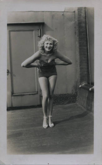 Untitled [Woman leans forward, hands on hips, door in background]