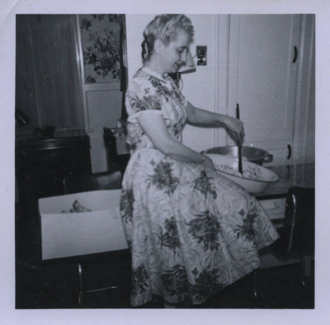 Untitled [Woman sits on table, stirs something in pot]