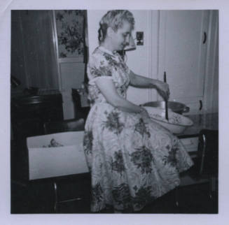 Untitled [Woman sits on table, stirs something in pot]