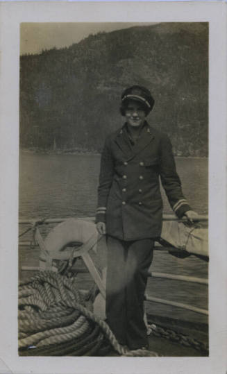 Untitled [Woman stands on ship, one hand on rail]