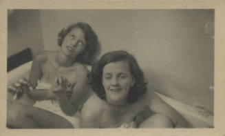Untitled [Two women sit on bathtub, wear towels]