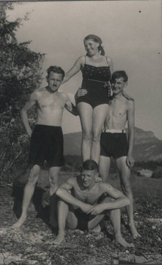 Untitled [Woman stands on man's shoulders, two men on either side of her]