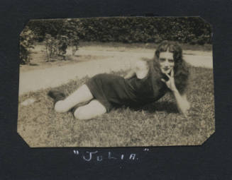 Untitled [Woman lies on lawn, rests face on hand]