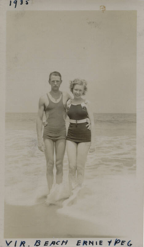 Untitled [Woman and man stand on beach, arms around each other]