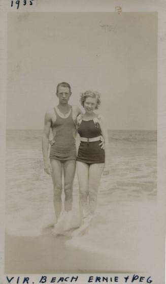 Untitled [Woman and man stand on beach, arms around each other]