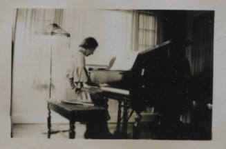 Untitled [Woman sits, plays piano]