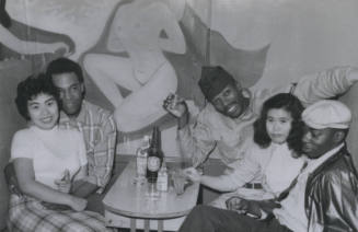 Untitled [Two women and three men sit in booth, drinks on table]