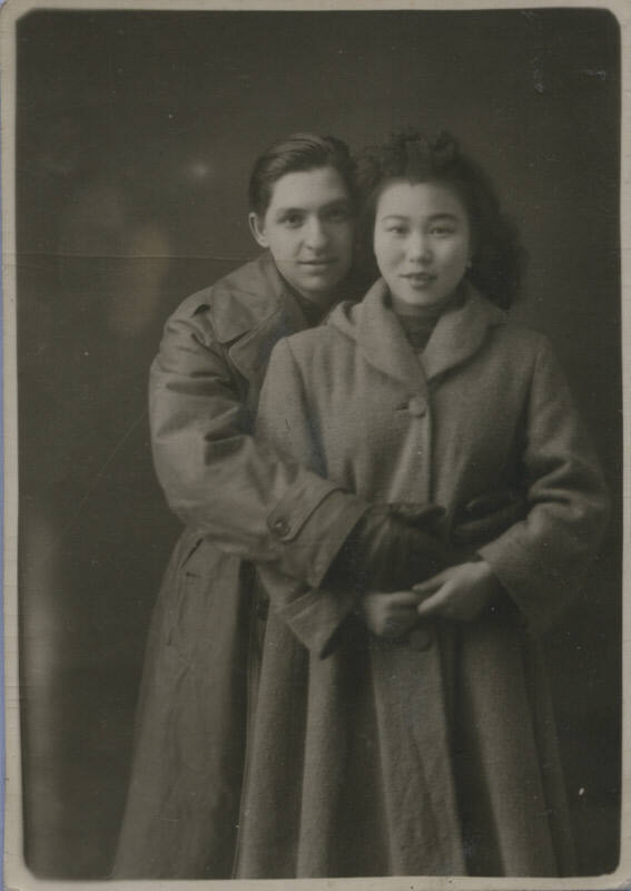 Untitled [Woman and man stand together, wear coats]