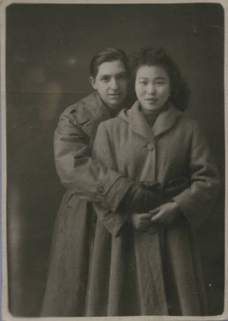 Untitled [Woman and man stand together, wear coats]