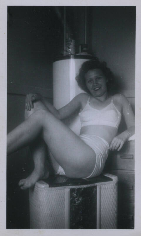 Untitled [Woman sits on heater]