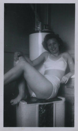 Untitled [Woman sits on heater]