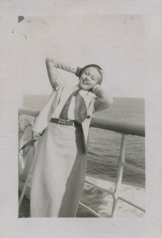 Untitled [Woman stands on ship's deck, hands behind head]
