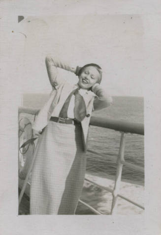 Untitled [Woman stands on ship's deck, hands behind head]