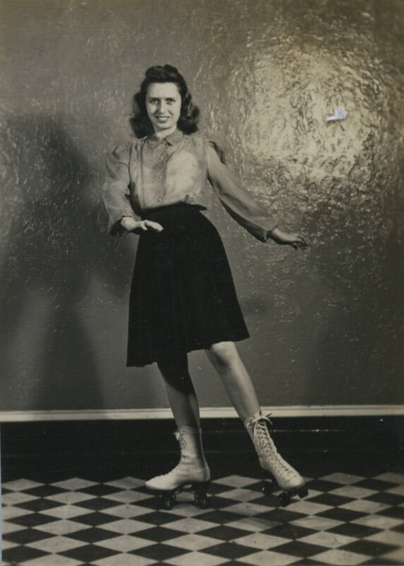 Untitled [Woman stands, hands to one side, wears roller skates]