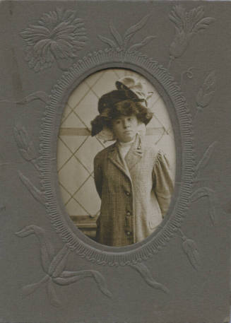 Untitled [Woman stands, hand behind her back, wears hat and coat]