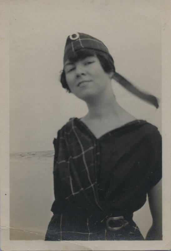 Untitled [Woman stands, body of water in background]