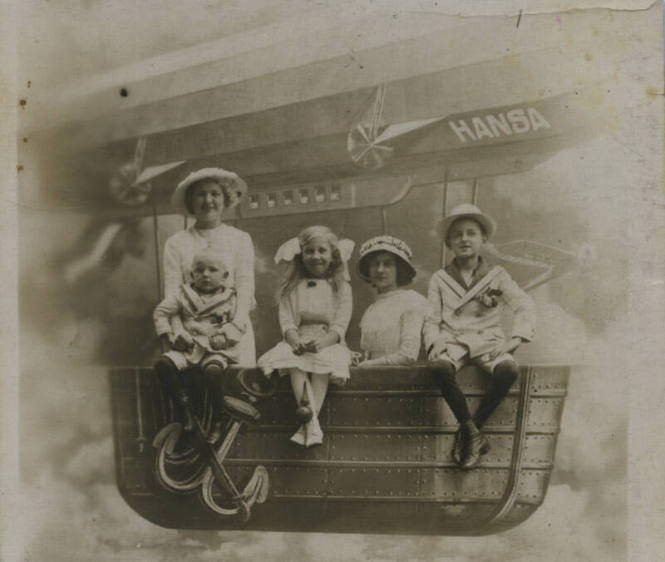 Untitled [Two women and three children sit on bench resembling airship]