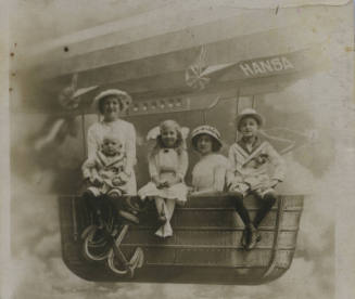 Untitled [Two women and three children sit on bench resembling airship]