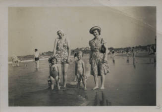 Untitled [Two women and two children stand on bench]