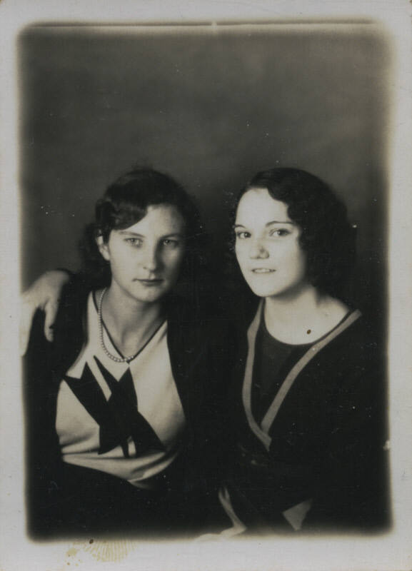 Untitled [Two women sit together, arms around each other]