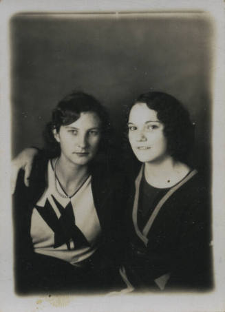 Untitled [Two women sit together, arms around each other]