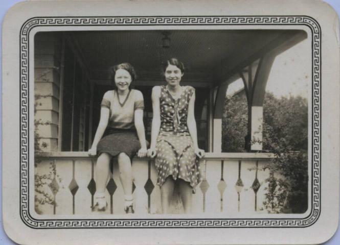 Untitled [Two women sit on porch ledge]