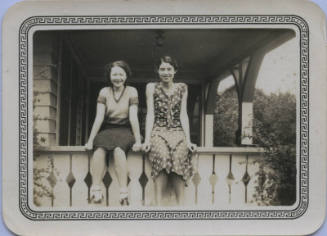 Untitled [Two women sit on porch ledge]