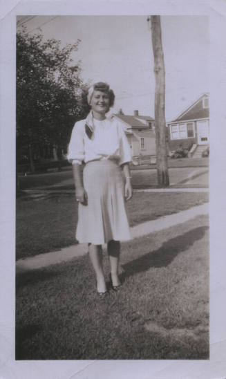 Untitled [Woman stands on lawn, hands by her sides]