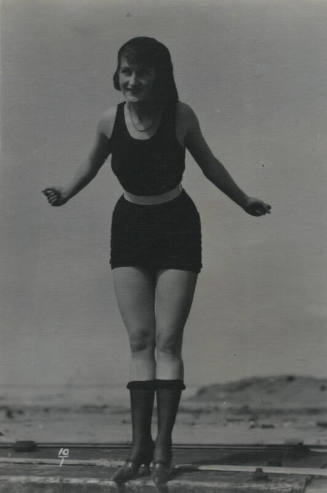 Untitled [Woman stands on ledge, hills in background]