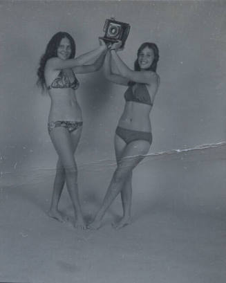 Untitled [Two women hold up camera]