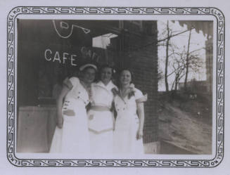 Untitled [Three women in uniforms stand together, sign that reads Cafe in background]