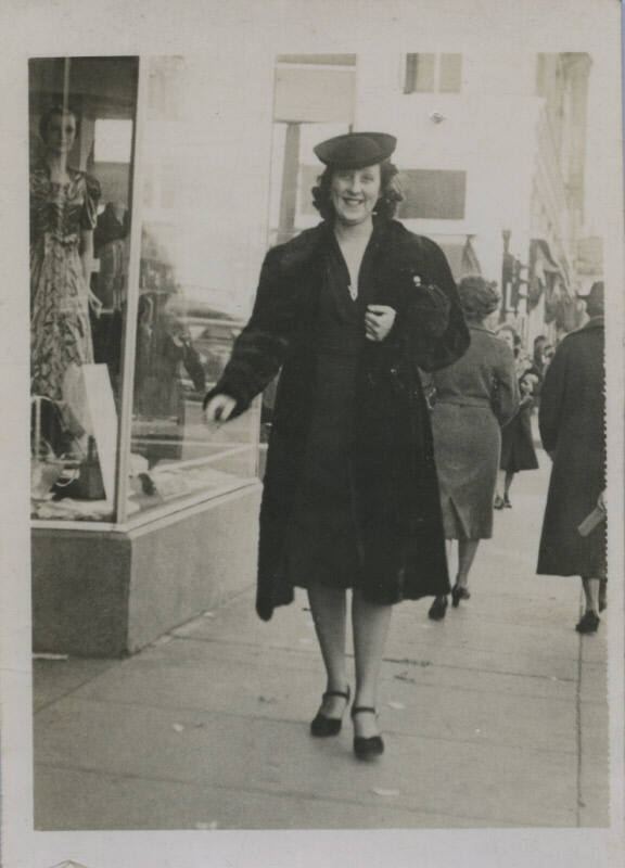 Untitled [Woman walks on street, mannequin on display in background]