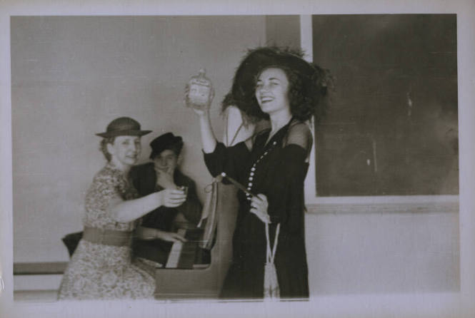 Untitled [Woman holds up bottole, one hand on hip]