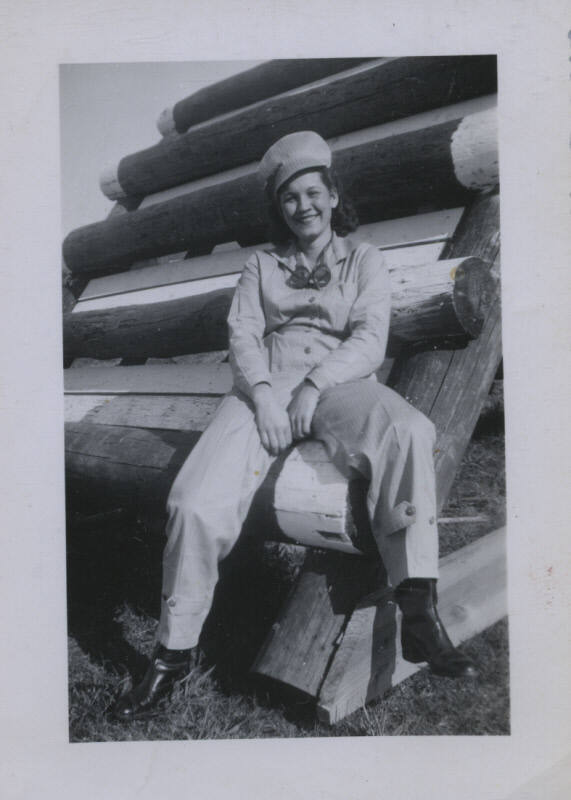 Untitled [Woman sits on wooden structure]