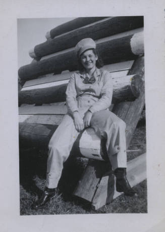 Untitled [Woman sits on wooden structure]