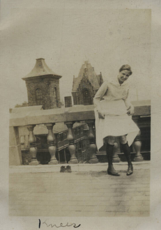 Untitled [Woman stands on rooftop, holds up skirt]