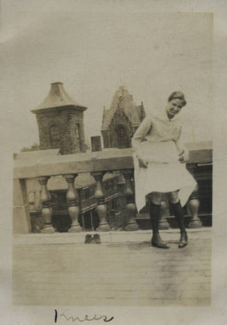 Untitled [Woman stands on rooftop, holds up skirt]