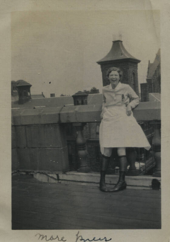 Untitled [Woman stands on rooftop, holds up skirt]