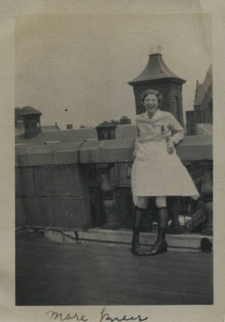 Untitled [Woman stands on rooftop, holds up skirt]