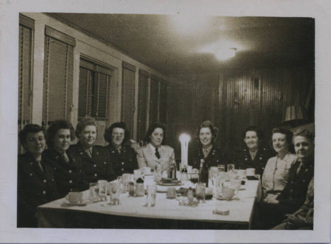Untitled [Nine women sit around table, wear uniforms]