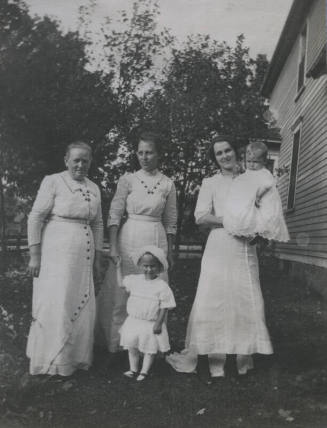 Untitled [Three women stand on lawn with two children]